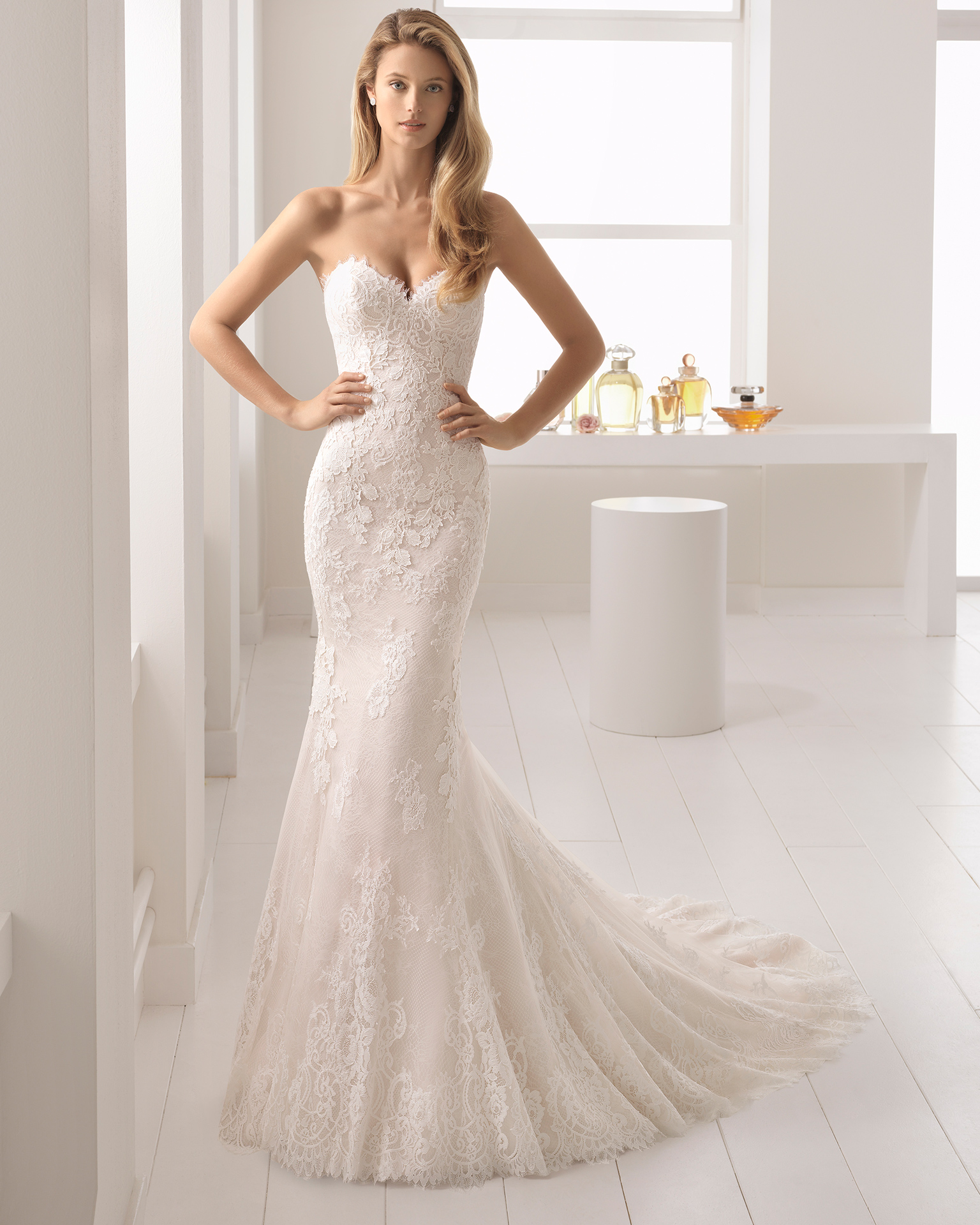 Rochie de mireasă în stil sirenă din dantelă și ghipură, cu decolteu în formă de inimă, de culoare nude și ecru.