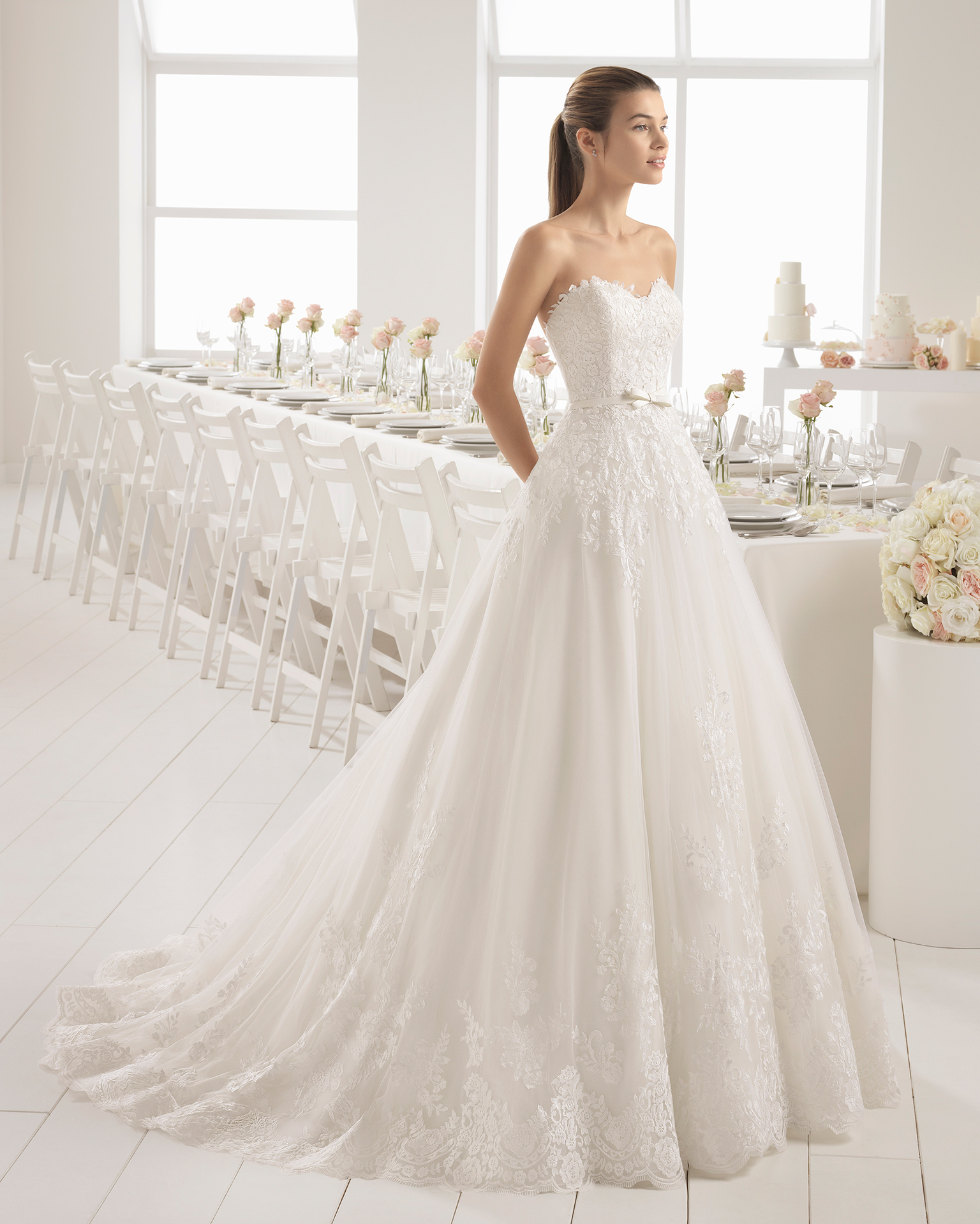 Romantic-style lace wedding dress with sweetheart neckline and bow at waist.
