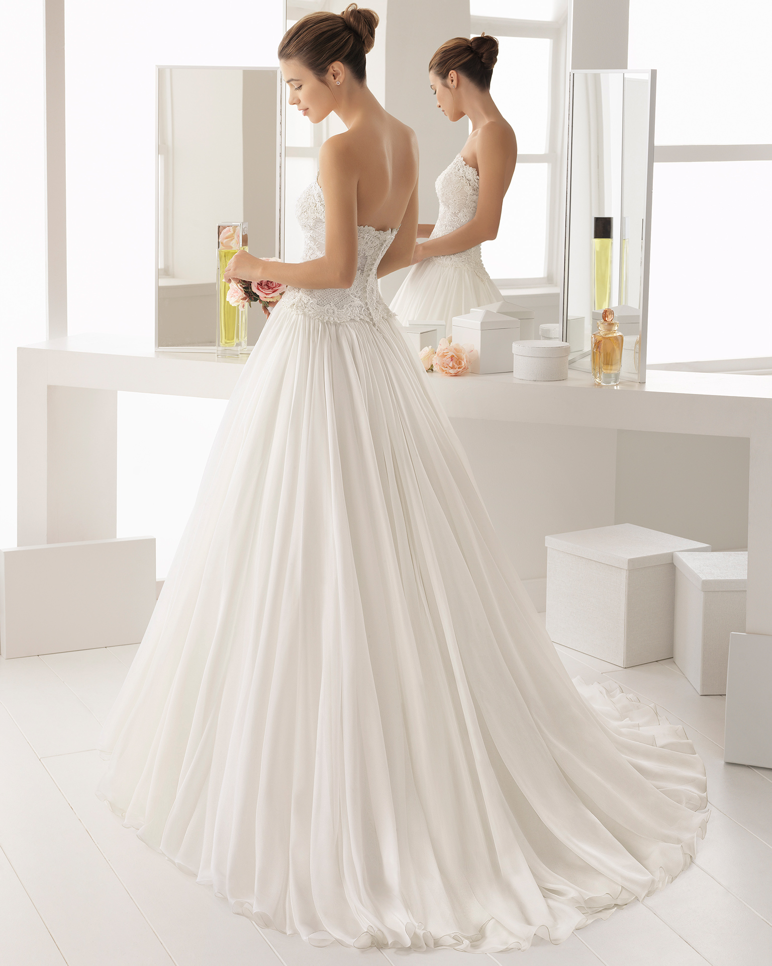 Abito da sposa stile romantico in chiffon, pizzo trasparente e strass, con scollo a balconcino.