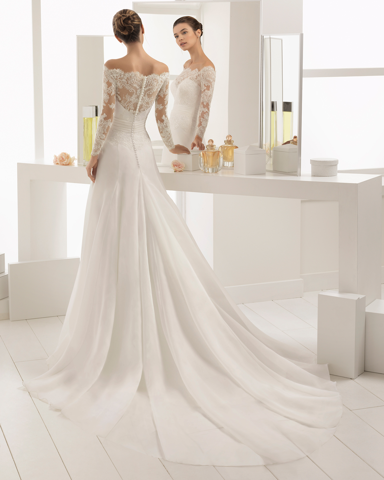 Romantic-style beaded lace and organza wedding dress with long sleeves and off-the-shoulder neckline.