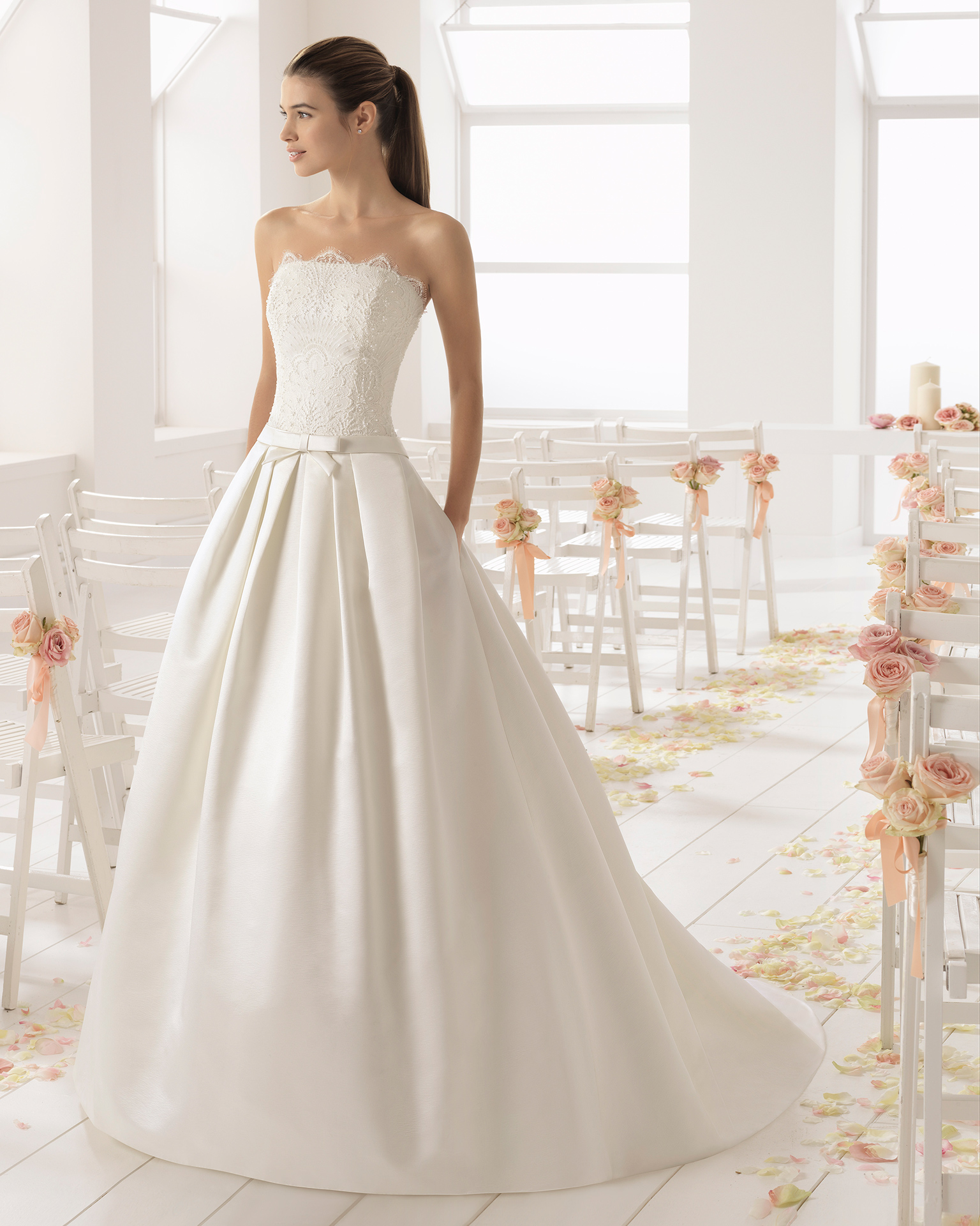 Abito da sposa stile classico in raso duchesse, pizzo e strass, con scollo a balconcino, colore avorio.