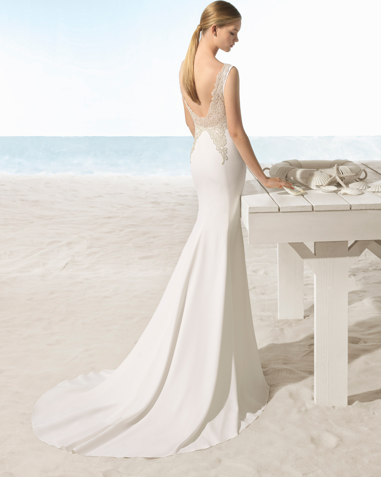 Mermaid-style crepe wedding dress with low back with beadwork detail.